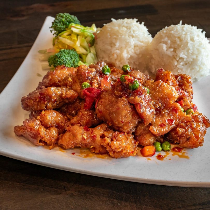 Nara Teriyaki and Pho's orange chicken with white rice and steamed broccoli on a white plate.